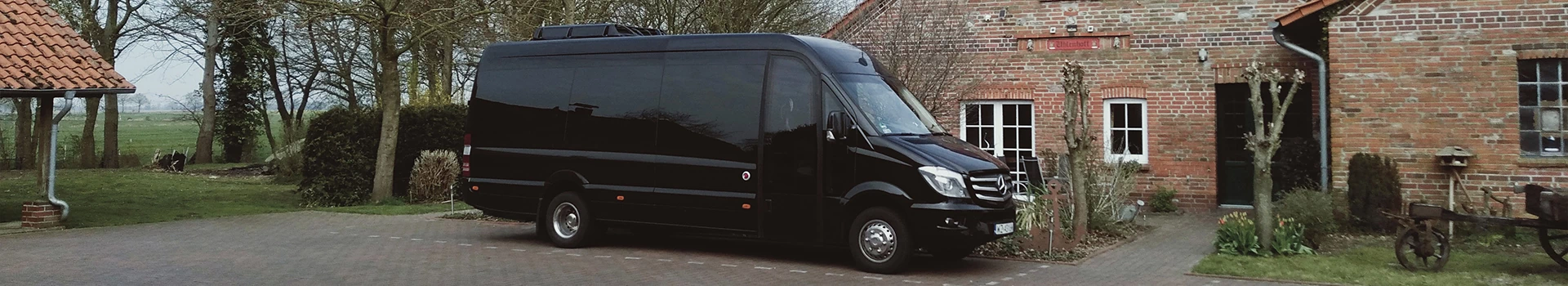 czarny bus zaparkowany przy domku
